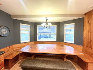 Cherry wood breakfast nook with large windows and an inviting chandelier