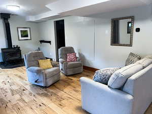 Living room featuring a wood stove and light hardwood flooring