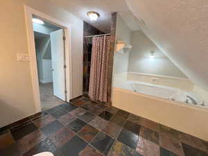 Bathroom with a textured ceiling and plus walk in shower