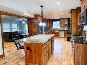 Kitchen with dark stone countertops, sink, a center island, and hardwood flooring