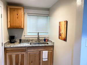 Kitchen with light stone counters and sink