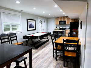 Recreation room with light hardwood / wood-style flooring