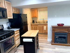 Kitchen with wood counters, light wood-type flooring, sink, and stainless steel range with gas stovetop