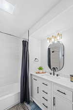 Bathroom featuring vanity and shower / tub combo with curtain