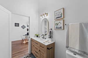 Bathroom featuring vanity, hardwood / wood-style flooring, and toilet