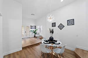 Dining room with french doors, hardwood / wood-style flooring, and a notable chandelier