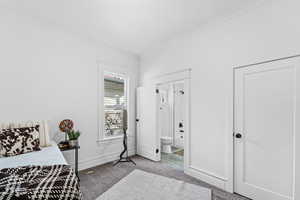 Bedroom with carpet, ensuite bathroom, and crown molding