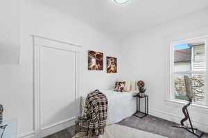 Sitting room featuring a healthy amount of sunlight, carpet floors, and ornamental molding