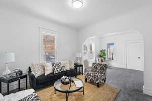 Carpeted living room with ornamental molding