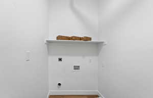 Washroom with electric dryer hookup, hookup for a washing machine, and hardwood / wood-style flooring