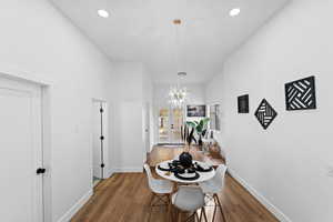 Dining area with dark hardwood / wood-style flooring and an inviting chandelier