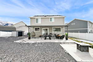 Back of property featuring a mountain view, a patio area, a shed, and an outdoor living space with a fire pit