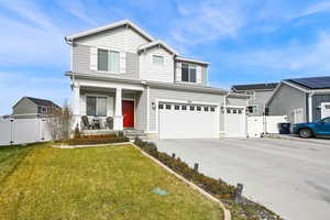 View of front of property featuring a porch, a garage, and a front lawn