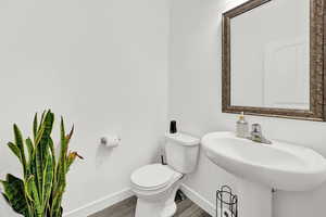 Bathroom featuring sink, wood-type flooring, and toilet