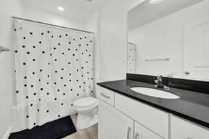 Bathroom featuring hardwood / wood-style floors, vanity, and toilet