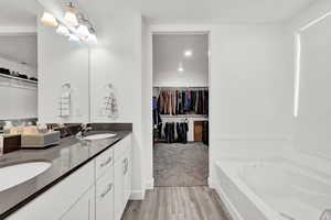 Bathroom featuring hardwood / wood-style flooring, vanity, and a bath