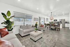 Living room featuring light wood-type flooring and an inviting chandelier