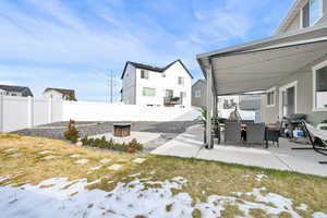 Yard covered in snow featuring a fire pit and a patio area