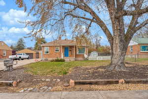 Ranch-style home with a garage, an outdoor structure, and a front yard