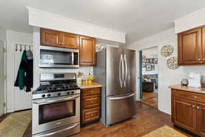 Kitchen featuring tasteful backsplash, dark wood-type flooring, and stainless steel appliances