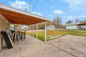 View of patio featuring a shed