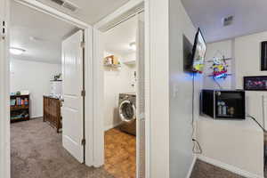 Corridor featuring carpet flooring and washer / dryer