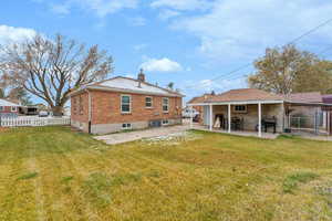 Rear view of property with a yard and a patio area