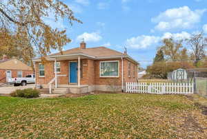 Bungalow-style home with a shed and a front yard