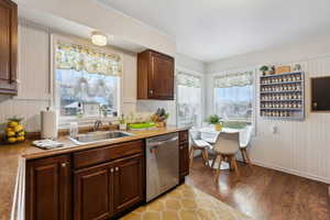 Kitchen with a wealth of natural light, dishwasher, hardwood / wood-style flooring, and sink