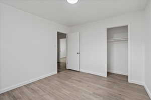 Unfurnished bedroom featuring light hardwood / wood-style flooring and a closet