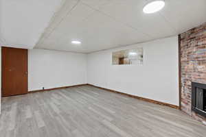 Basement featuring a fireplace and light hardwood / wood-style flooring