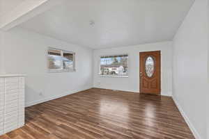 Entryway with beam ceiling and dark wood-type flooring