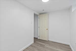 Empty room with light hardwood / wood-style floors