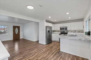 Kitchen with white cabinets, dark hardwood / wood-style floors, sink, and appliances with stainless steel finishes