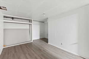 Unfurnished bedroom with a closet and hardwood / wood-style floors