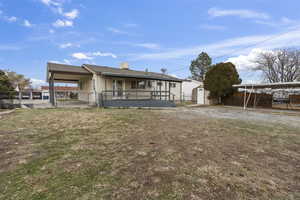 Back of property with a yard and a storage unit