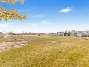 View of yard featuring a rural view and an outdoor structure