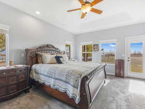 Bedroom with carpet, a raised ceiling, and ceiling fan