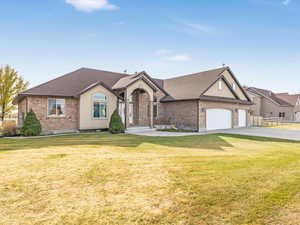 View of front facade featuring a garage and a front lawn