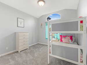 Carpeted bedroom with vaulted ceiling