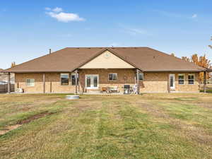 Rear view of property with a yard and a patio area