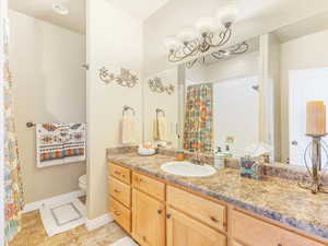 Bathroom featuring tile patterned floors, vanity, a shower with shower curtain, and toilet