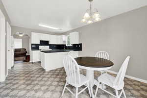 Dining room with plenty of natural light and ceiling fan with notable chandelier