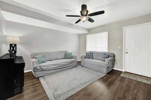 Living room featuring ceiling fan and dark hardwood / wood-style floors