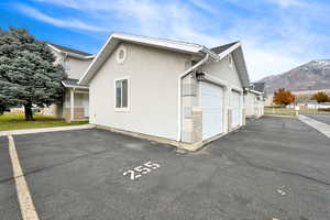 View of side of home with a mountain view and a garage