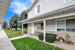 Doorway to property featuring a yard and covered porch