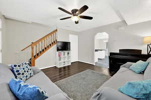 Living room featuring ceiling fan and dark hardwood / wood-style flooring