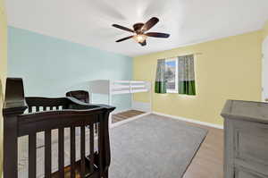 Bedroom with ceiling fan and wood-type flooring