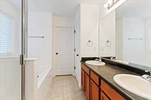 Bathroom with vanity, tile patterned floors, and a tub