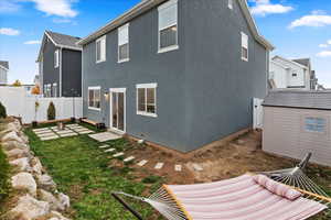 Rear view of property featuring a storage shed